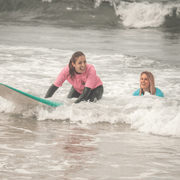 Girl smiling while enjoying the surf classes with pur school